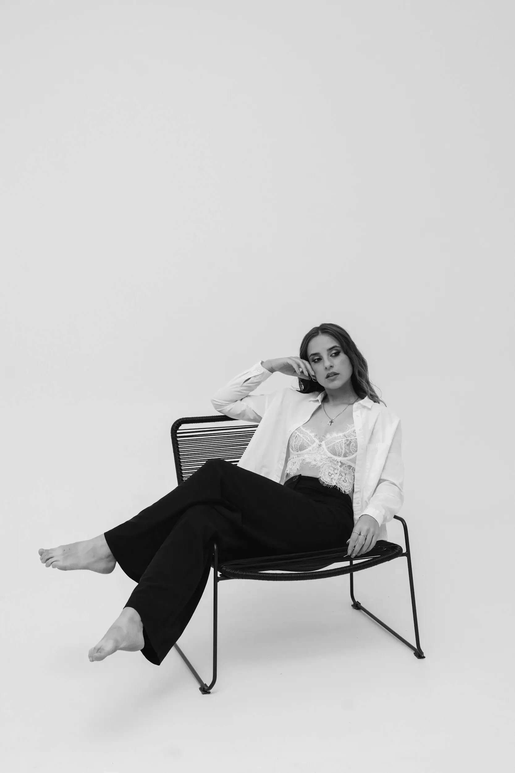Black and white portrait of client seated in chair at our self-directed photography studio in Windsor